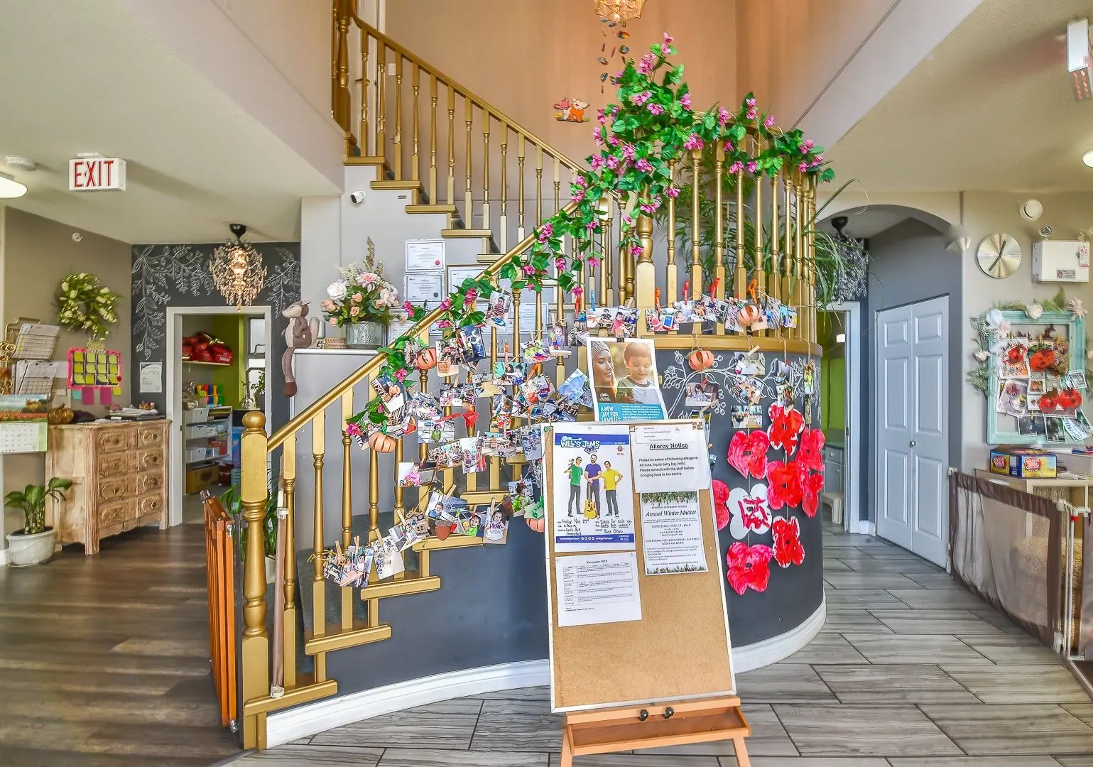 The entry hall of the centre with its staircase and a display board of children's photographs