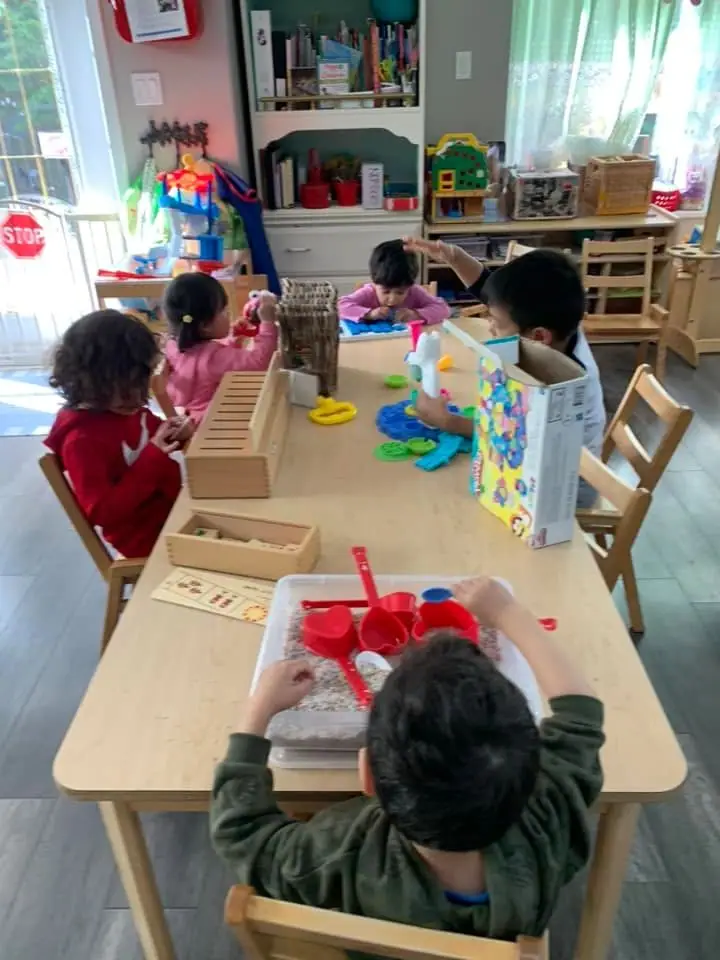 Children rolling and cutting playdough at the activity table
