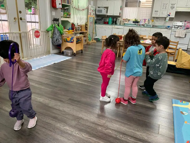 Children playing with a skipping rope in the open play room