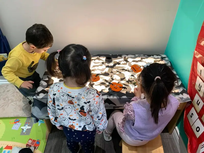 Children decorating Halloween cookies laid out on a table