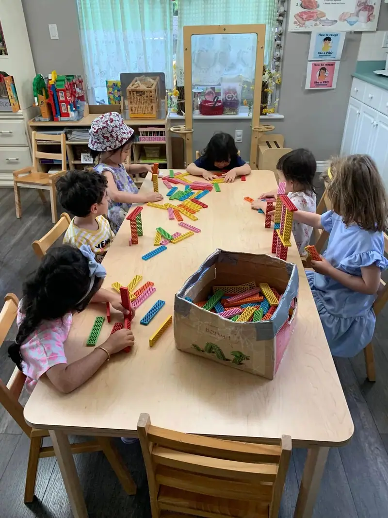Children sorting brightly coloured craft sticks around a big table