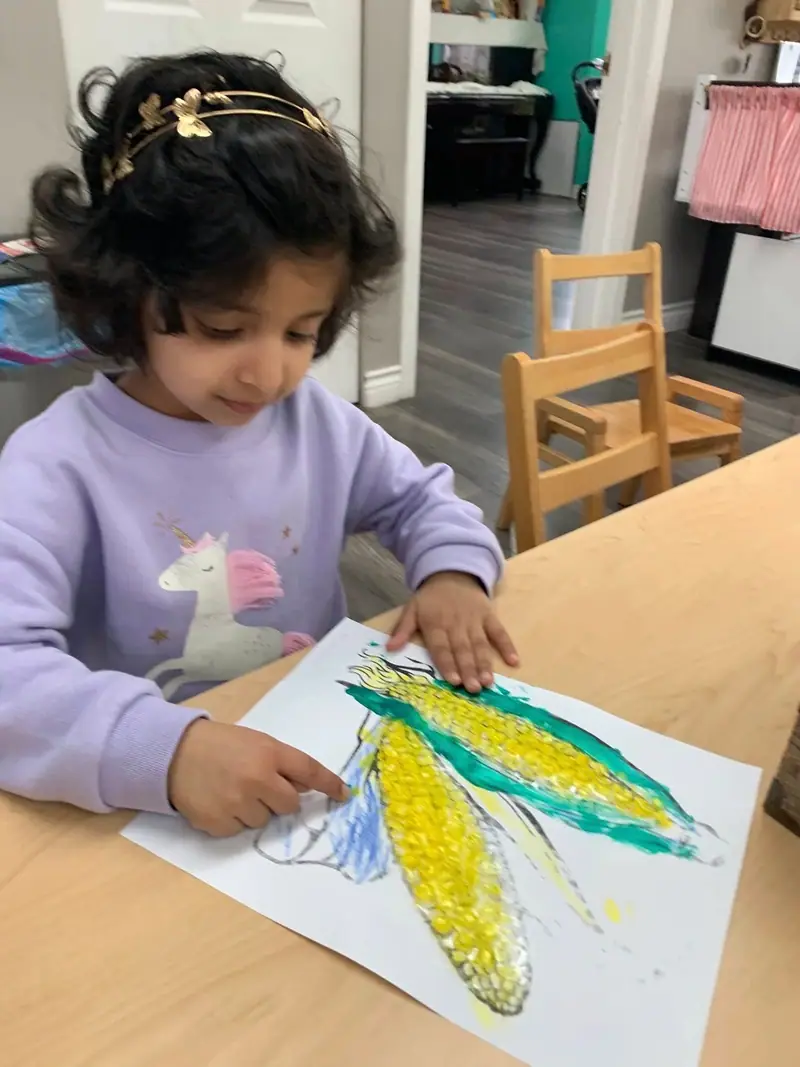 A child drawing corn with oil pastels