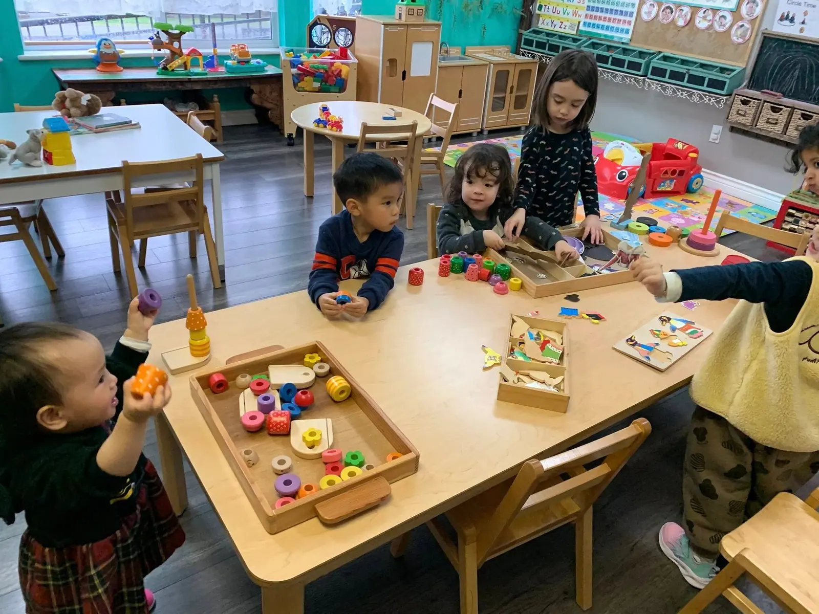 Children playing with wooden fruit and vegetable trays