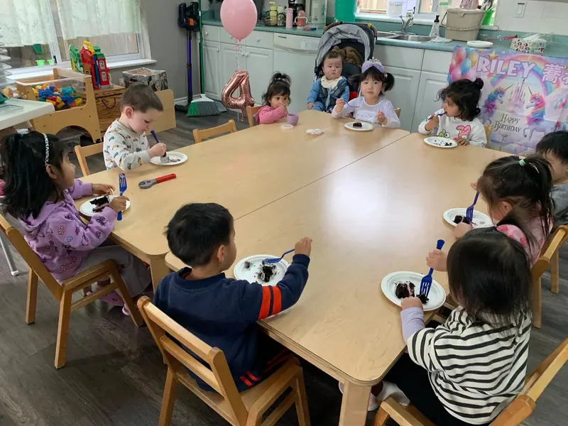 Children seated around the big table for snack