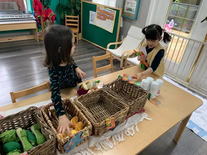 Children playing shop with baskets of felt vegetables