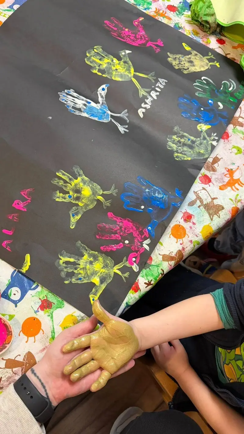 A large group mural covered in brightly coloured handprints