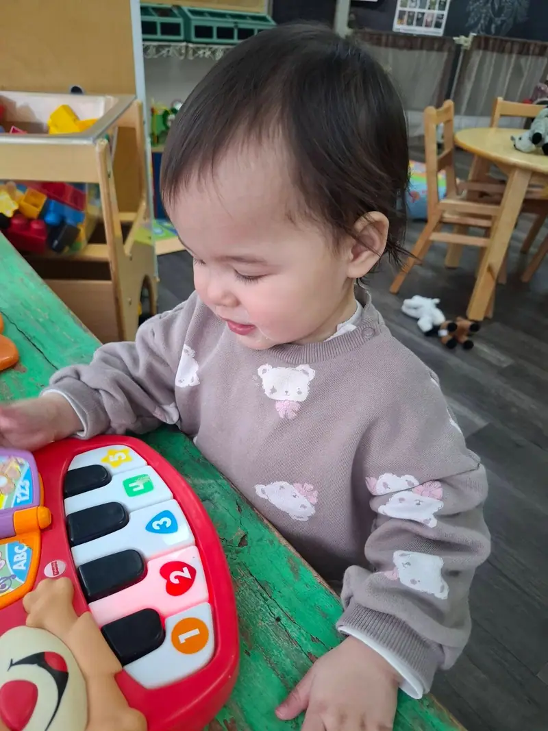 A toddler playing a light-up toy piano