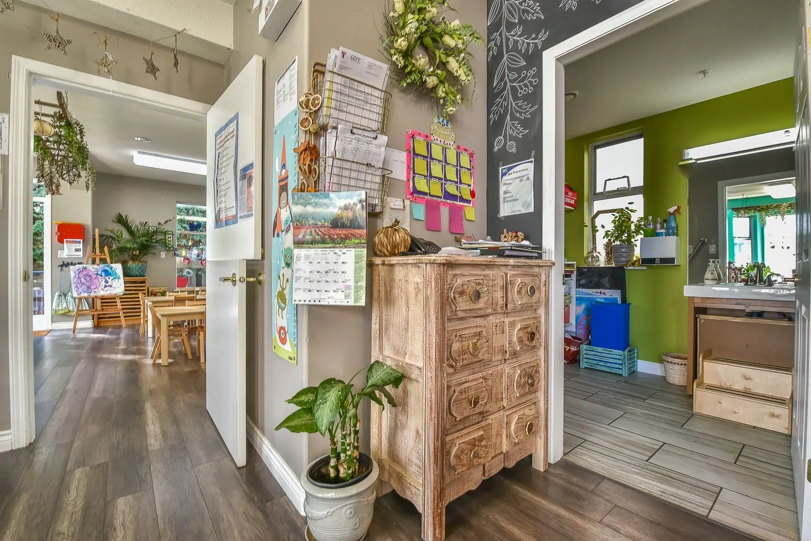 The art corner, with a wooden dresser, chalkboard and children's work on display
